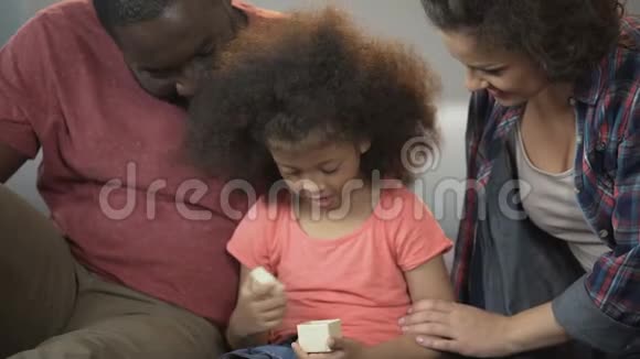 可爱的小女孩打开小礼物感谢慈爱的父母视频的预览图