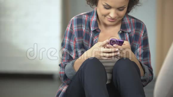 微笑的年轻女子与朋友在电话社交媒体应用聊天视频的预览图