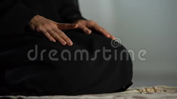 伊斯兰文化清真寺传统黑头巾妇女跪在祈祷席上视频的预览图