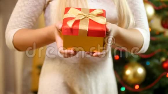 特写4k视频年轻女子手持圣诞礼物并在镜头中展示视频的预览图