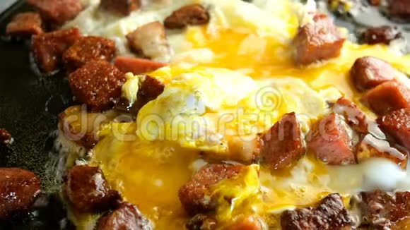 做美味的热菜煎鸡蛋或煎蛋卷和肉丁脆腊肠和培根在热脂肪中炸视频的预览图