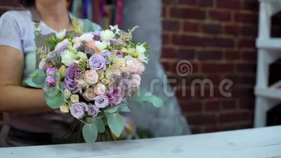 专业花艺师在花艺设计工作室展示鲜花婚礼花束视频的预览图