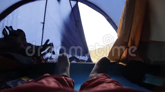 一个穿羊毛袜子躺在帐篷里的人的脚视频的预览图