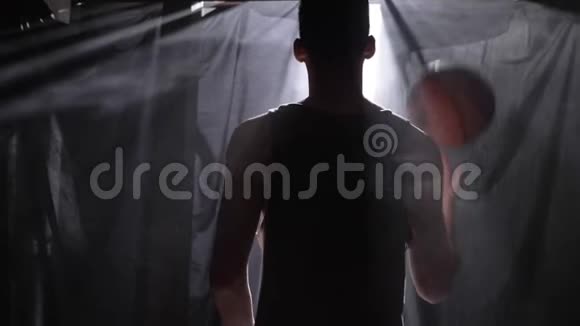 篮球运动员在黑暗的雾蒙蒙的房间里等待和打球视频的预览图