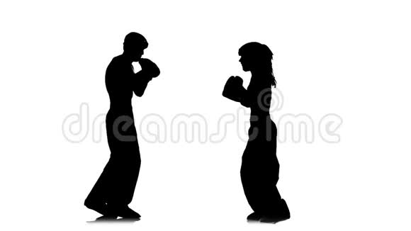 拳击手女孩踢在对手的头上剪影白色背景慢动作视频的预览图