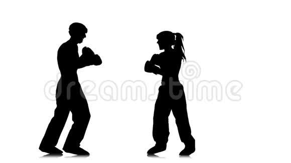 拳击手女孩踢在对手的头上剪影白色背景慢动作视频的预览图