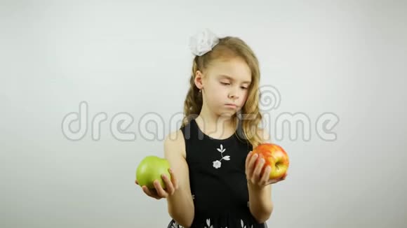 非常漂亮的女孩手里拿着一个红色和绿色的苹果选择并提供绿色苹果视频的预览图