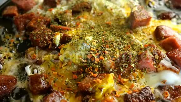 做美味的热菜煎鸡蛋或煎蛋卷和肉丁脆腊肠和培根在热脂肪中炸视频的预览图