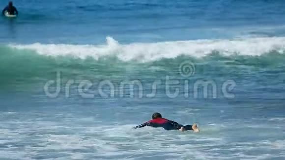 男子尝试在冲浪板上游泳通过海浪在海洋夏季积极运动视频的预览图