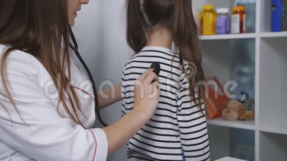 女医生用听诊器检查医院里可爱的小女孩动作缓慢视频的预览图