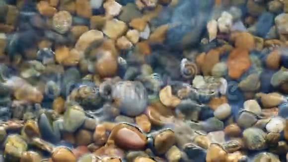 海滩上的卵石在水中缓慢运动特写镜头视频的预览图