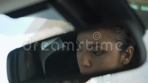 坐在车里的女士后视镜里的倒影可疑的可疑的阴毒贩子视频的预览图