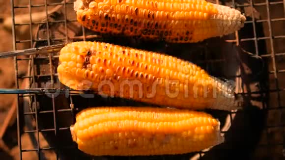 早晨把玉米放在炉子上用阳光洒在木炭上视频的预览图