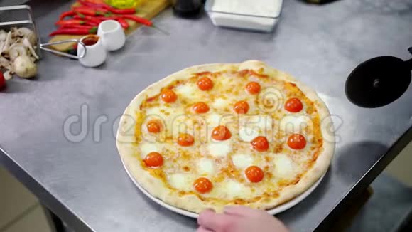 餐厅厨房一位厨师把披萨切成碎片视频的预览图