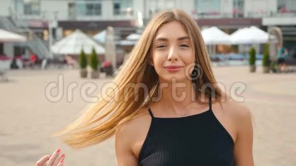 脸浅棕色头发的年轻女人看着镜头近距离城市街头背景的肖像美女视频的预览图