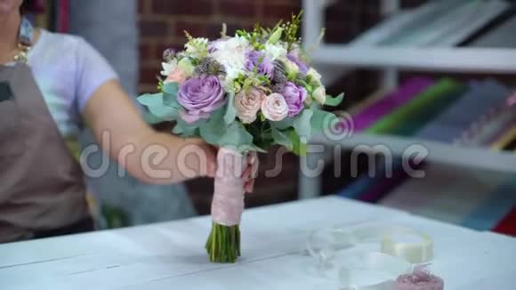 专业花艺师在花艺设计工作室展示鲜花婚礼花束视频的预览图