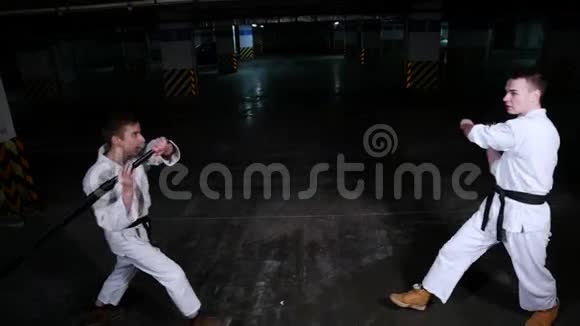 两个穿和服的年轻人在停车场训练剑战视频的预览图