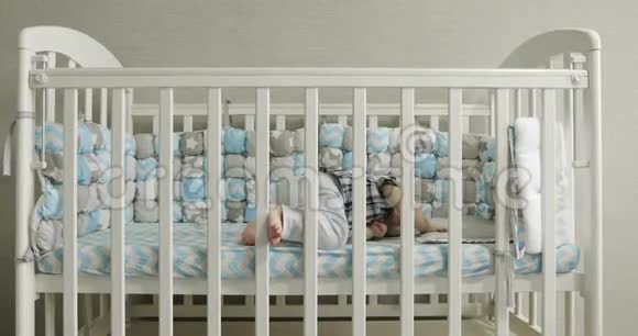 快乐的孩子站在婴儿床上视频的预览图