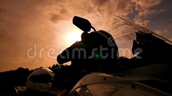 摩托车手在日落慢速运动中准备运动摩托车视频的预览图