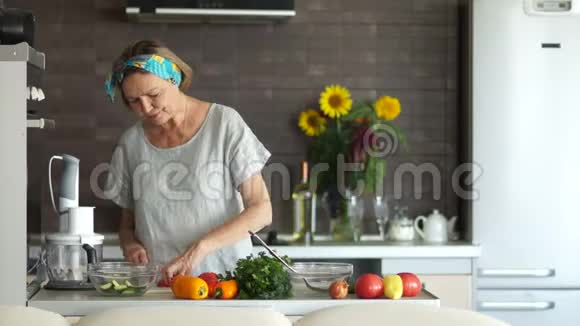 成熟的女人站在厨房里切西红柿他试了一下赞许地点头素食妈妈视频的预览图