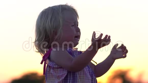 哭的孩子日落时在草地上的孩子视频的预览图