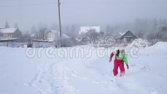 女孩在白雪覆盖的道路上奔跑孩子们的假日是多云的冬日视频的预览图