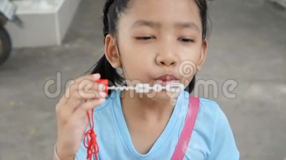 亚洲小女孩快乐地玩着泡泡气球视频的预览图
