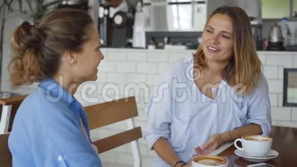 最好的朋友在咖啡馆约会漂亮的女孩边喝咖啡边说话视频的预览图