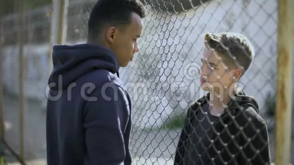 两个不同民族的男孩在交谈贫富之间隔着篱笆视频的预览图
