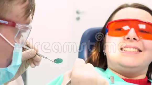 害怕的病人和医生试图检查她在牙医办公室牙科护理的概念媒体一个年轻女孩视频的预览图