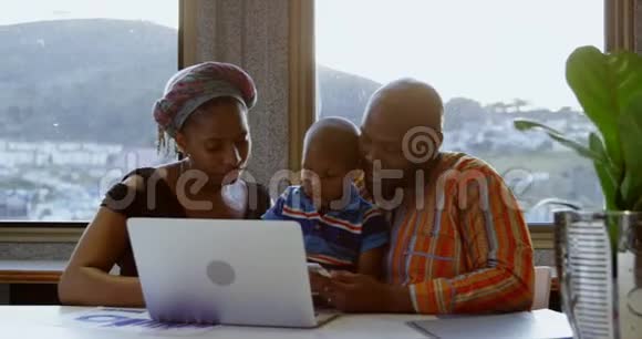 父母和儿子在家使用笔记本电脑和数码平板电脑视频的预览图
