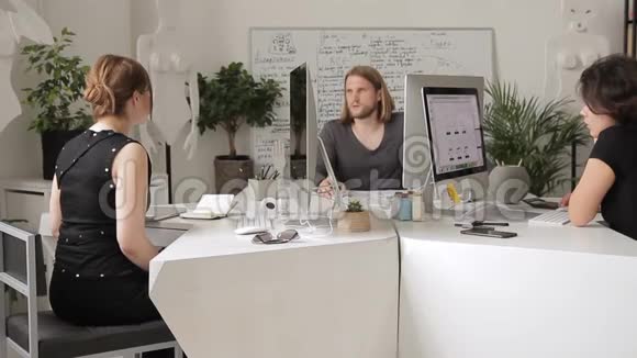 同事男人女人解释坐在电脑后面的工作计划视频的预览图