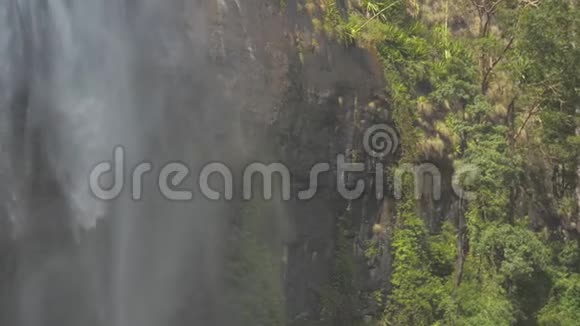 岩石悬崖上的瀑布绿树和草慢慢视频的预览图