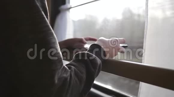 那个男孩站在火车窗口手里拿着一块平板电脑坐火车旅行度假旅游环游世界视频的预览图