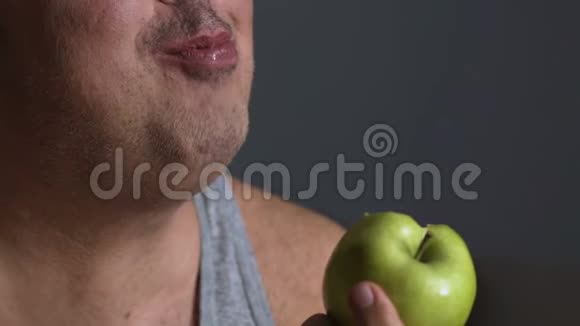 肥胖男性咀嚼绿苹果节食和卡路里计数健康的生活方式视频的预览图