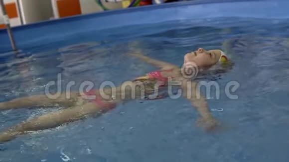 小女孩在后面的游泳池里游泳视频的预览图