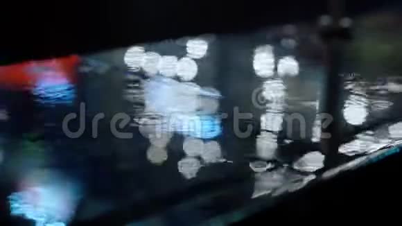 近景雨滴落在水坑上城市人行道上灯光反射视频的预览图