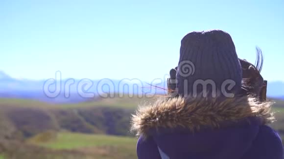 观景台上的旅游女孩用望远镜看着群山慢悠悠视频的预览图
