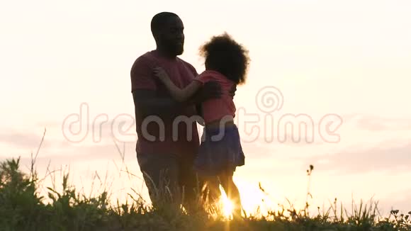 非裔美国人爸爸和他的小女儿在灿烂的夕阳下玩耍视频的预览图