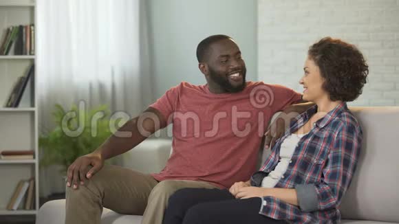 幸福的一家人坐在沙发上互相聊天享受消遣视频的预览图