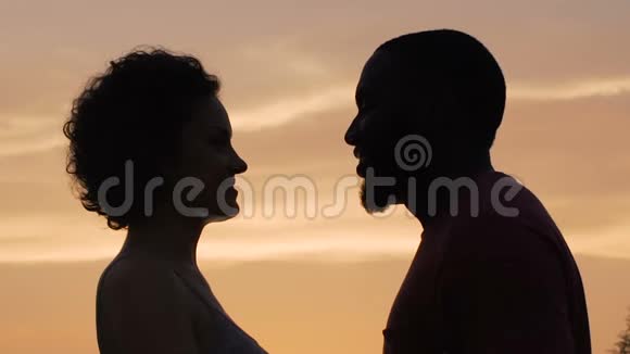 男女剪影轻轻相触夕阳背景视频的预览图