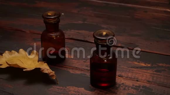 秋景摄影木制背景上的小瓶子和橡木叶视频的预览图