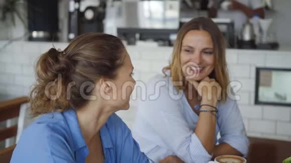 最好的朋友在咖啡馆约会漂亮的女孩边喝咖啡边说话视频的预览图