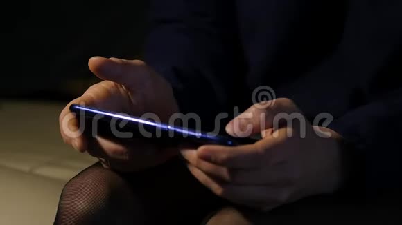 关闭女人她的手指在晚上使用智能手机女孩在手机上浏览互联网慢动作视频的预览图
