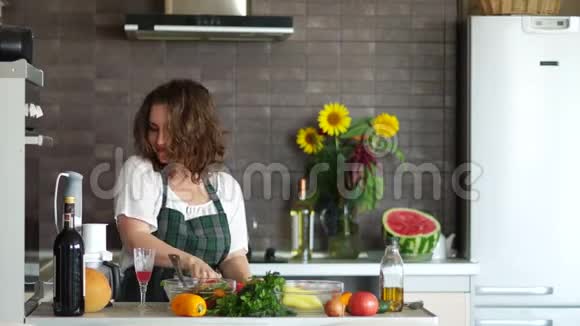 年轻迷人的家庭主妇在厨房准备浪漫的晚餐明亮的现代化厨房内部母亲日子视频的预览图