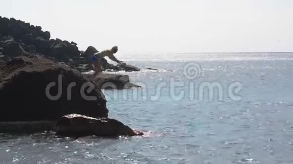 勇敢的人毫无畏惧地从悬崖跳到波涛汹涌的大海视频的预览图