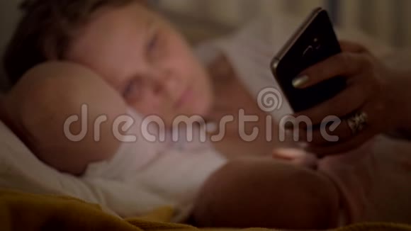 夜间哺乳时使用手机的妇女视频的预览图