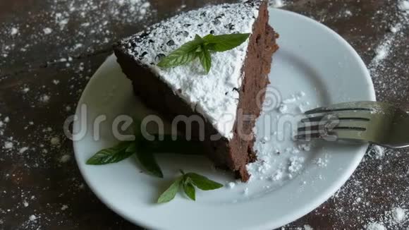 一块巧克力蛋糕放在白色盘子上旁边放着新鲜的薄荷叶视频的预览图