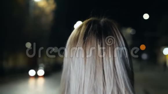 年轻女性的户外肖像留着长长的金发涂着红色的口红在傍晚的城市里显得很时髦视频的预览图