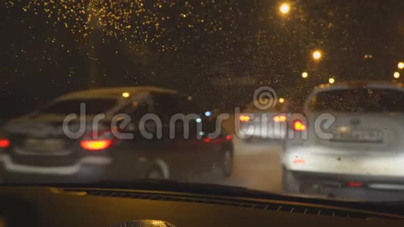 晚上掉在汽车挡风玻璃上冬天城市的夜间交通视频的预览图